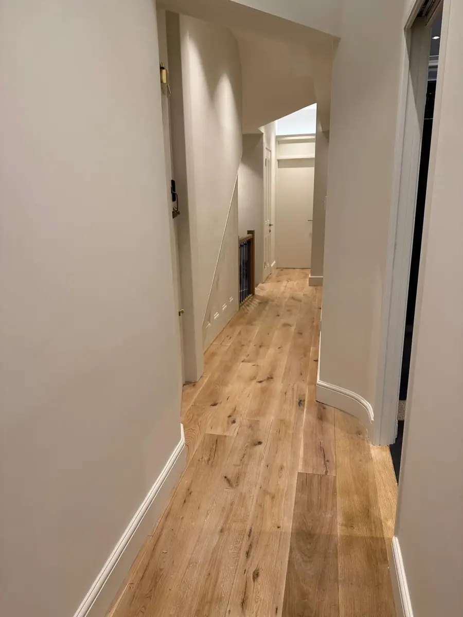 Bright hallway with a wide-plank engineered oak floor and white skirting boards
