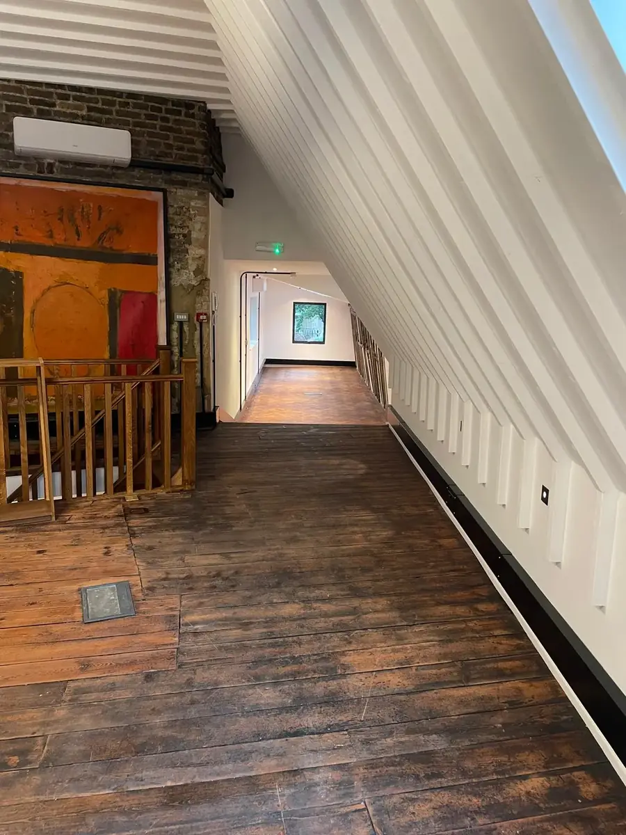 Attic landing with wide timber floorboards and an oak balustrade